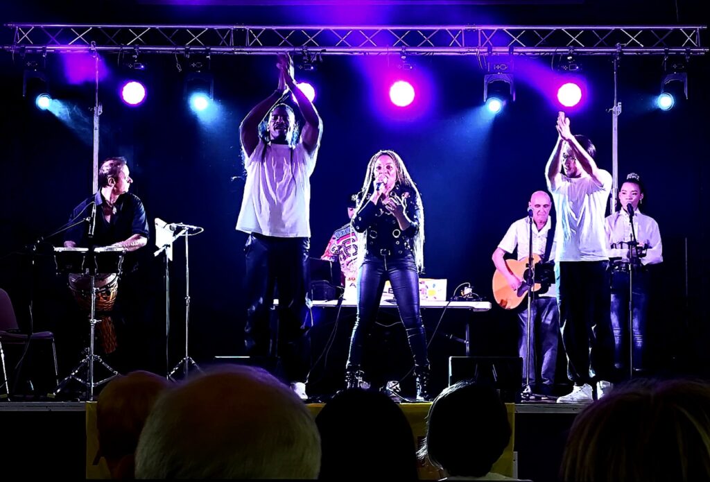 Concert live illumin-event en intérieur avec chanteuse et musiciens, ambiance festive en Occitanie