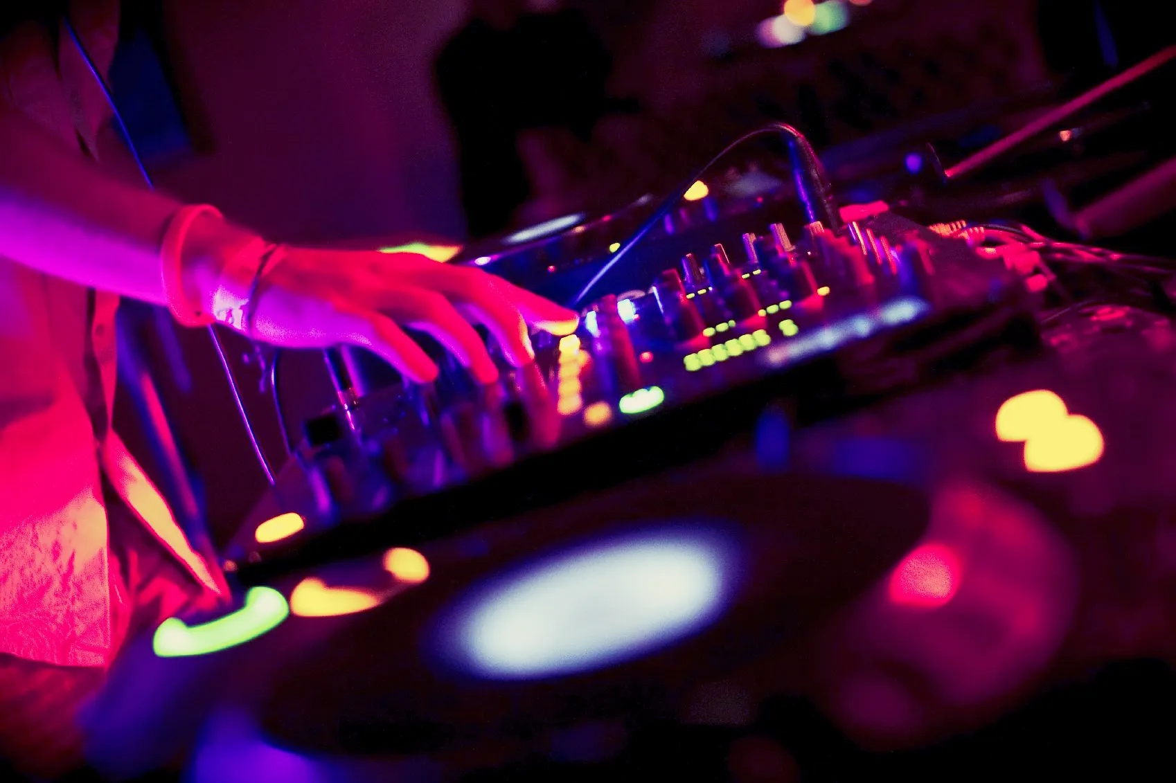 DJ en mix live illumin-event avec lumières néon colorées en soirée club en Occitanie