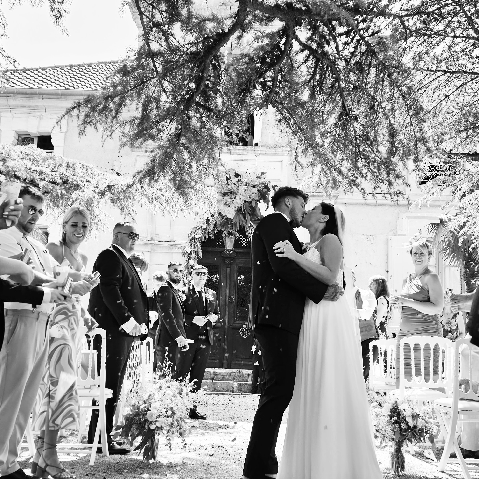 Mariage en plein air illumin-event avec baiser des mariés sous un arbre, invités en fête en Occitanie