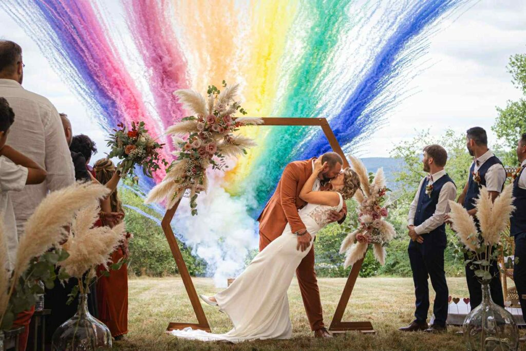 Mariage en plein air illumin-event avec nuage de fumée arc-en-ciel et arche florale pampas en occitanie