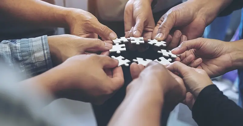 Mains assemblant un puzzle collaboratif illumin-event en occitanie